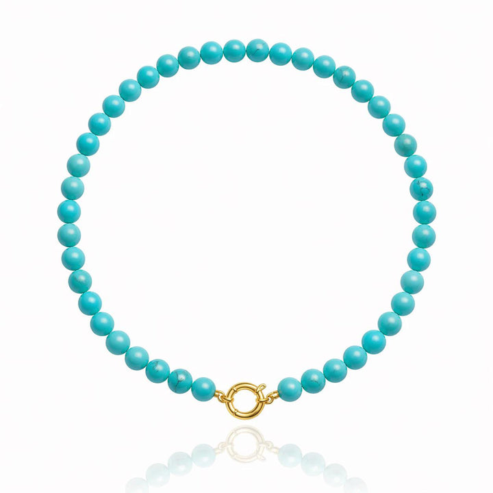 Turquoise bead strand laid flat with a gold bolt ring charm holder clasp