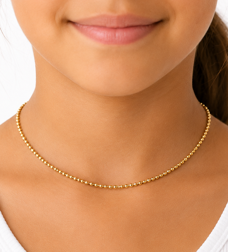 Minimalist fine gold bead choker worn close at the neckline with a white top