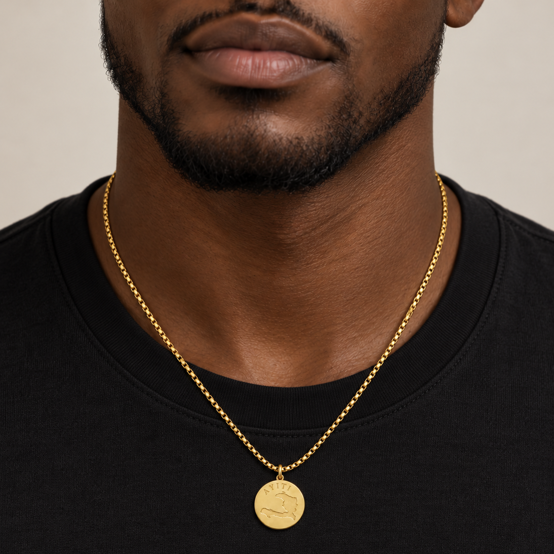 Ayiti coin chain worn over a black crew-neck tee, pendant resting mid-chest