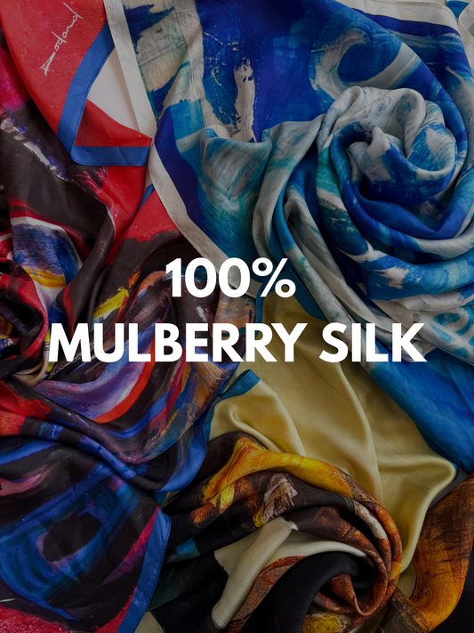 Folded printed mulberry silk scarves stacked together, showing different formats