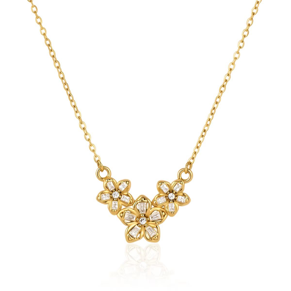 Three crystal-set flowers clustered on a fine gold chain, laid flat on white