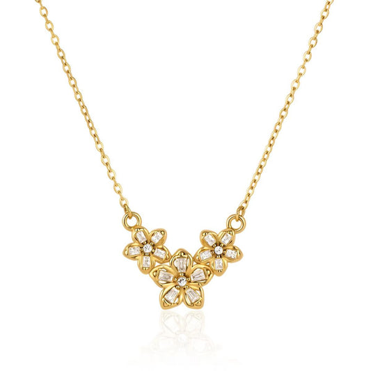 Three crystal-set flowers clustered on a fine gold chain, laid flat on white